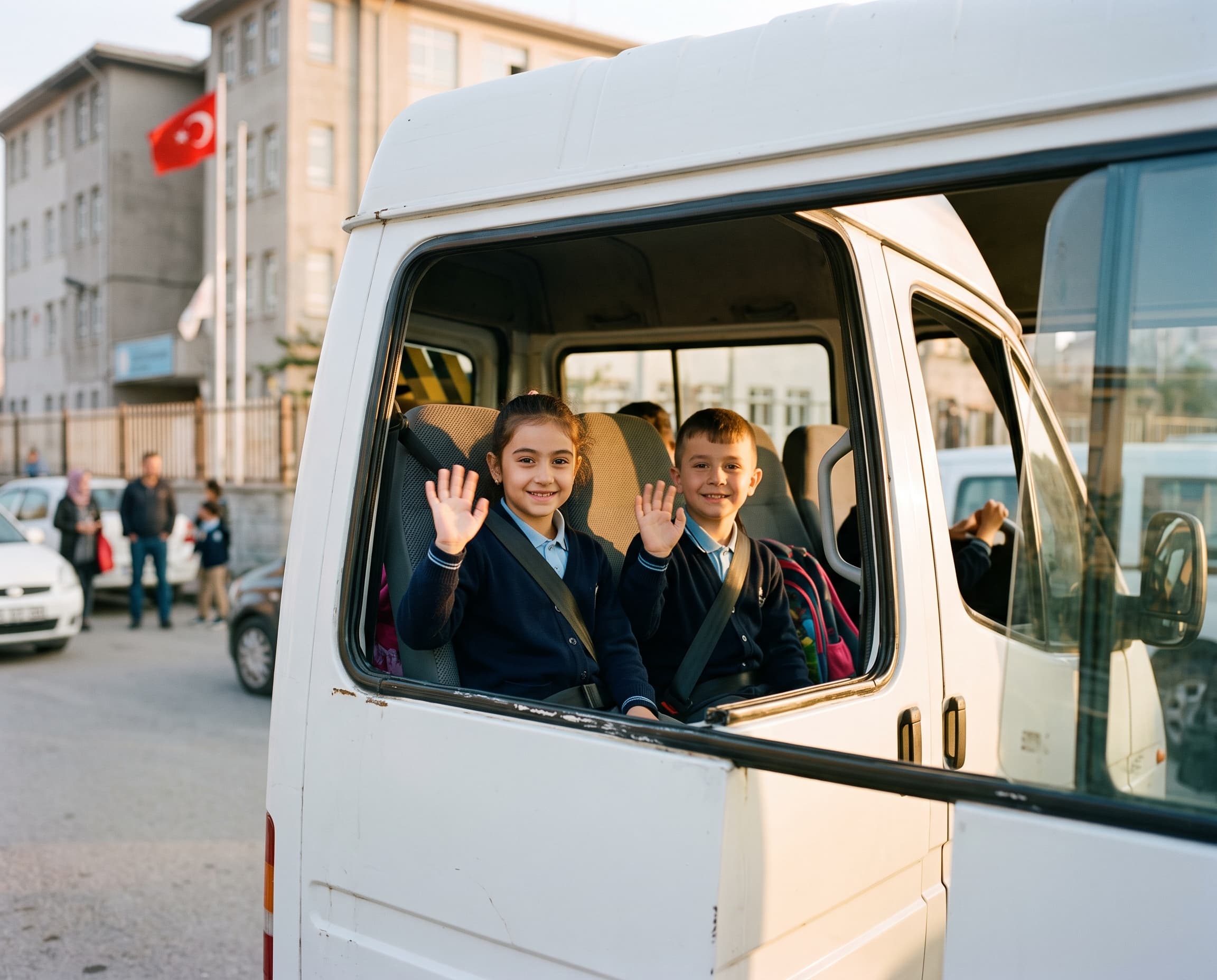 Servis penceresinden el sallayan öğrenciler